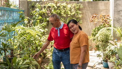 Loving Asian senior couple admiring their beautiful garden together