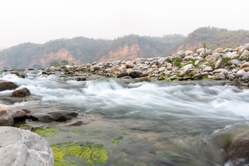 Long exposure of the flowing Kosi river in Jim Corbett, Uttarakhand, India. - obrazy, fototapety, plakaty
