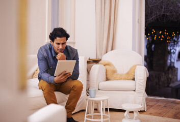 Tablet, reading and man on sofa in living room for online blog on social media, mobile app or...