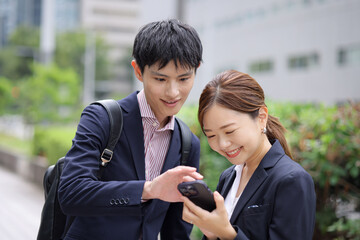 スマートフォンを見る男女のビジネスマン