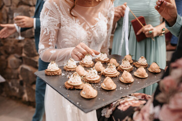 Coziness and style. Modern event design. Table setting at wedding reception. Floral compositions with beautiful flowers and greenery, candles, laying and plates on decorated table