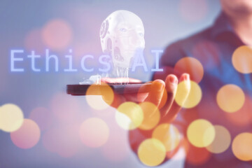 A person holding a cell phone with the words Ethics AI and robot hologram, Concept of the...
