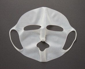 Cosmetic silicone mask on black background. Health care concept. Top View.