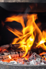 Burning coals and wood in a metal grill for frying meat and vegetables. Cooking on a campfire.