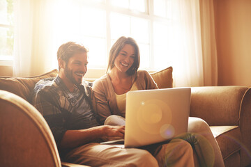 Happy, relax and couple on sofa with laptop for watching movies, entertainment and streaming in...