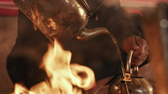 Man pouring water into a tea pot