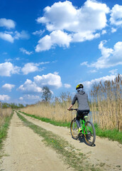 Woman riding a bicycle on a sunny spring day. Outdoor recreation.