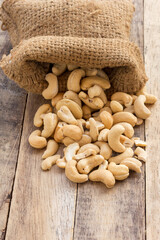 Cashew nut in sack bag on wood table