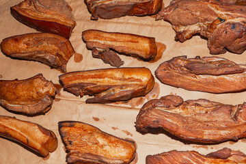 A batch of pieces of finished smoked lard on paper.