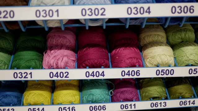 Colorful cotton yarn. Numbered thread bobbins in professional tailor atelier, wide collection of fabric thread reels for embroidery or clothes repair in dressmaker workshop. Concept Needlecraft