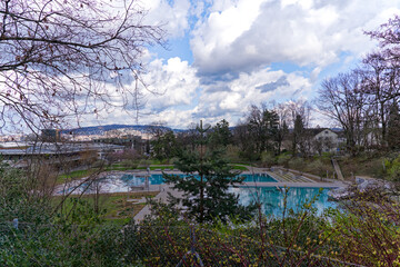 Fototapeta na wymiar Scenic view of empty outdoor swimming pool of Heuried sport center at Swiss City of Zürich on a cloudy spring day. Photo taken March 21st, 2024, Zurich, Switzerland.