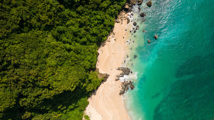 Indonesia's Lombok Island Birds eye view beach scene with clear blue water and green jungle behind