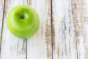 Green apple on wooden white background