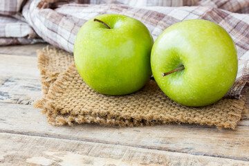 Green apple with leaves on burlap