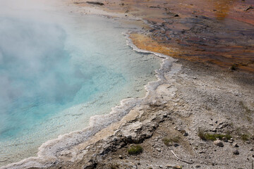 Heiße Quelle mit türkisblauem Wasser und rotem Gestein