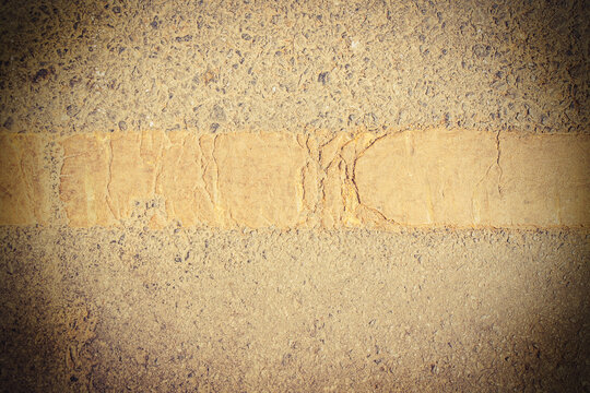 Road asphalt texture with yellow line.