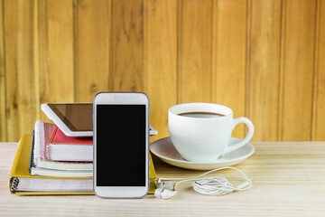 Smart phone,coffee cup,and stack of book on wooden table