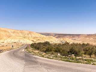 Empty Asphalt Road in the Dry Desert under the Blue Sky and Hot Sun in Jordan. Old bedouin village