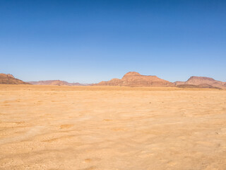 Fototapeta na wymiar Wadi Rum Desert In Jordan. Yellow and Orange Desert Sand under the Blue Sky