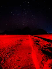 Papier Peint photo Lavable Rouge Red light on an empty path under the milky way stars. Night stars landscape