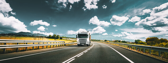 White Truck Or Traction Unit In Motion On Road, Freeway. Asphalt Motorway Highway Against Background Of Mountains Landscape. Business Transportation And Trucking Industry. - 765526964