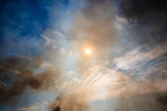 A few small fires making smoke in the sky caused by buring off. Central Australia.