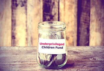 Coins in glass money jar with Fund for Underprivileged Children fund