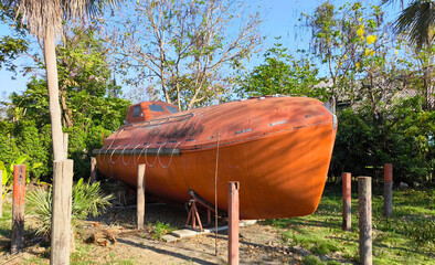 Old orange inclosed lifeboat or rescue boat on a land