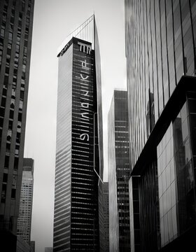 Stark black and white urban photography featuring distinct building signage. The image captures the essence of corporate architecture amidst the city's hustle.