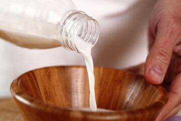 Pouring milk into wooden bowl