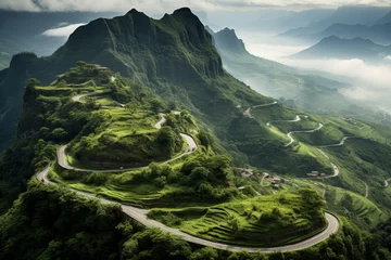 Foto op Canvas Aerial view of winding serpentine road in lush green summer mountains surrounded by mist and fog © Nikolai