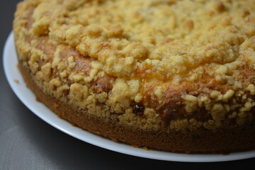 Kitchen, delicious homemade pie with pumpkin and apricot pieces placed on a white plate.