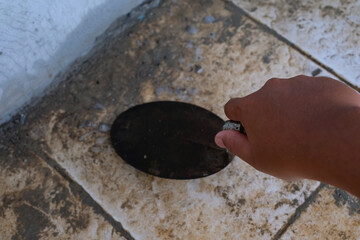 A hand scraping a cement stain on the floor. A worker is scraping the floor using a spatula. Industrial Photography. House chores. Industrial Construction. Shot in Macro lens
