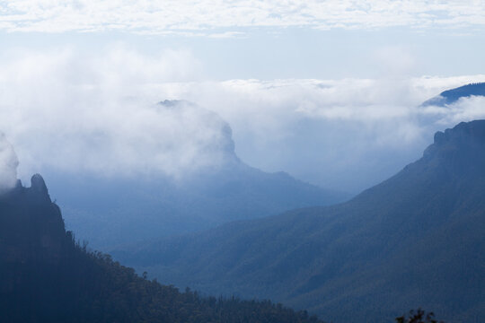 Layered mountains and valleys shrouded in cloud and mist