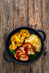 Tasty roast ribs with baked potatoes and sauerkraut salad on wooden table
