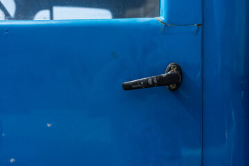 A fragment of an old car door and a door handle close-up.