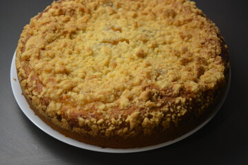 Kitchen, delicious homemade pie with pumpkin and apricot pieces placed on a white plate.