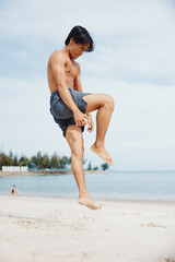 Fototapeta na wymiar Muscular Asian Athlete Enjoying a Sunset Run on the Beach, Exuding Strength and Serenity