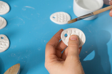 Creator is using white air dry clay for making decor to EASTER holiday. Creating hobby recreation activity that involves fingers. DIY crafting Modern art 