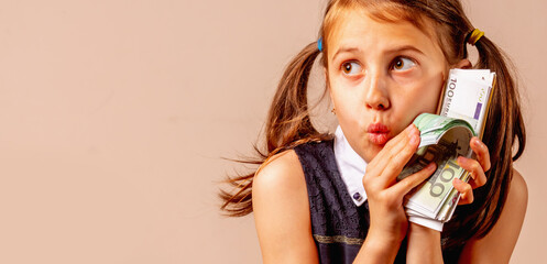 Funny portrait of happy young girl holding Euro money in her hands. Copy space, horizontal image.