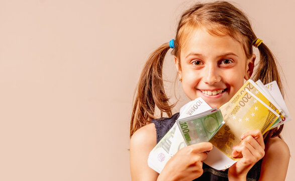 Portrait of young pretty happy girl holding Euro money in her hands. Copy space for design. Horizontal image.