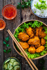Takeaway food - fried breaded chicken nuggets and vegetables on wooden table
