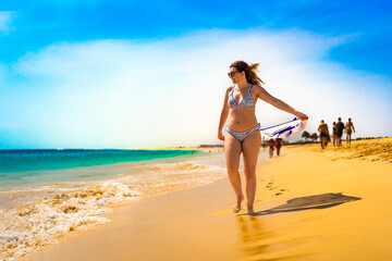 Beautiful mid-adult woman walking on sunny beach
- 765604770