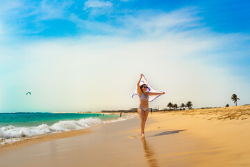 Beautiful mid-adult woman walking on sunny beach
- 765605179