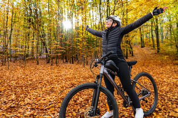 Woman riding bicycle in city forest in autumn scenery
- 765606556