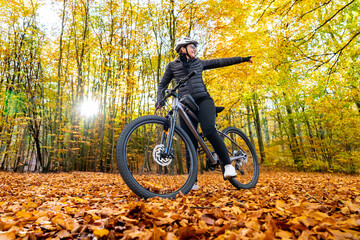 Woman riding bicycle in city forest in autumn scenery
- 765606566