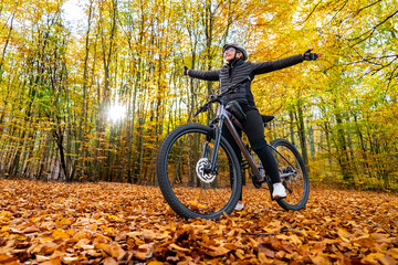 Woman riding bicycle in city forest in autumn scenery
- 765606781