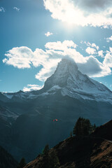 Matterhorn mountain with tourist playing parachute on blue sky in daylight at Switzerland