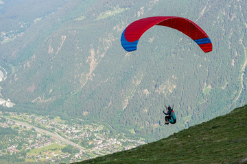 Paraglider flying above Chamonix, popular paragliding destination in French Alps
