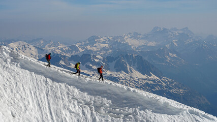 Group of experienced mountaineers descending Mont Blanc on sunny day, Chamonix, France